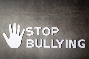 word “stop bullying” with hand sign on dark background